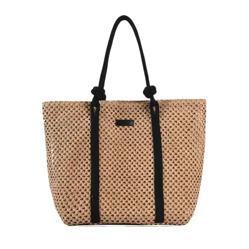 Flätad shoppingväska med svart rem och praktiskt design.