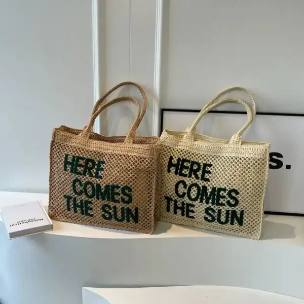 Flätad väska med text 'Here Comes The Sun', naturfärgad och ljusbeige, sommarväska.