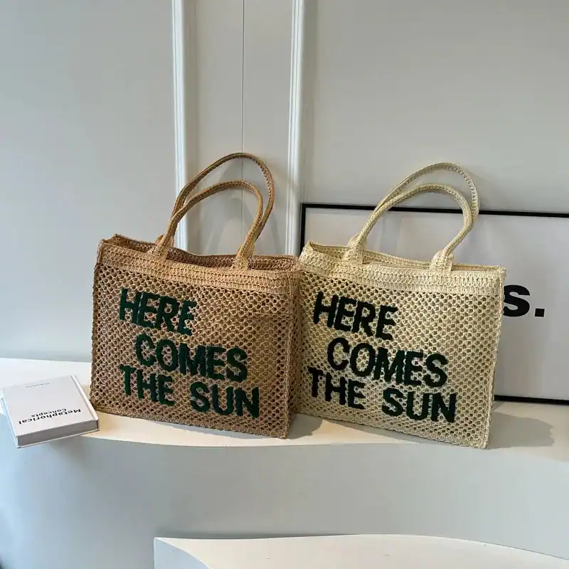 Flätad väska med text 'Here Comes The Sun', naturfärgad och ljusbeige, sommarväska.
