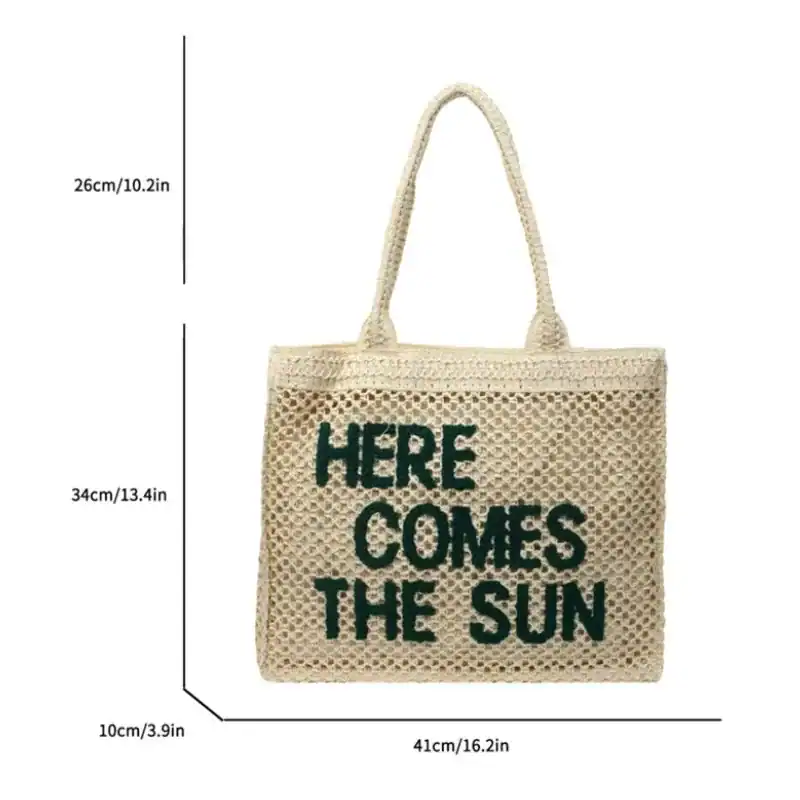 Flätad väska med text 'Here Comes The Sun', solig design, storlek 41x34 cm.