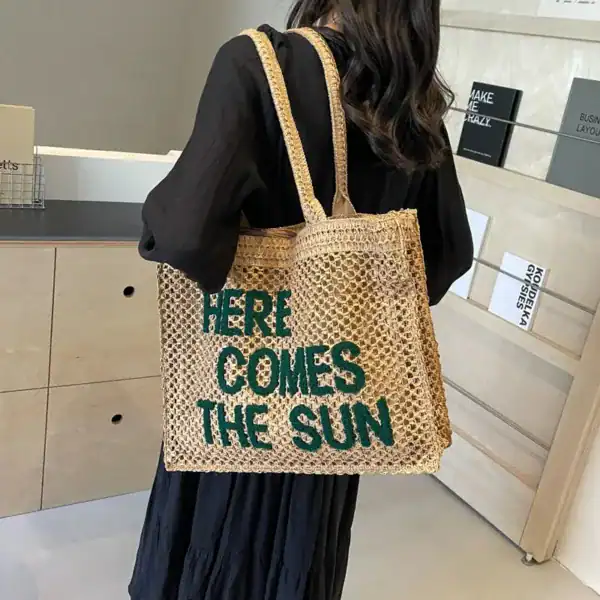 Flätad väska med text 'Here Comes The Sun', trendiga sommarväskor för kvinnor.