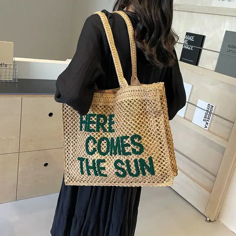 Flätad väska med text 'Here Comes The Sun', trendiga sommarväskor för kvinnor.