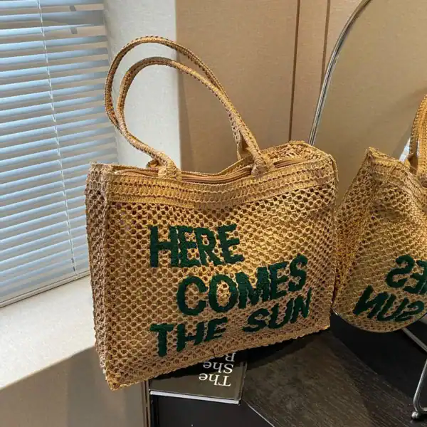 Flätad väska med text 'Here Comes The Sun', trendiga sommarväskor.