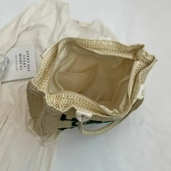 Flätad väska med text, ljusbeige, öppen topp, passar till sommar och strand.