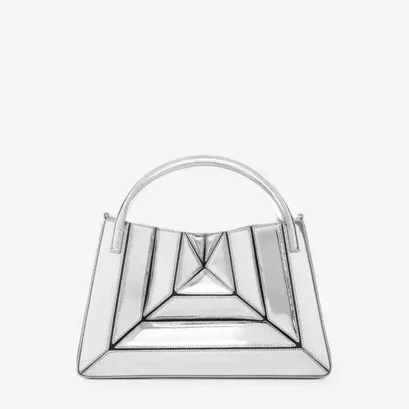 Flerfärgad väska i silver, geometrisk design med handtag.