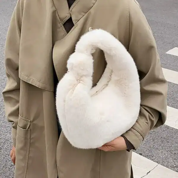 Grå fluffig hobo axelväska med mjuk pälsliknande yta och rund form.