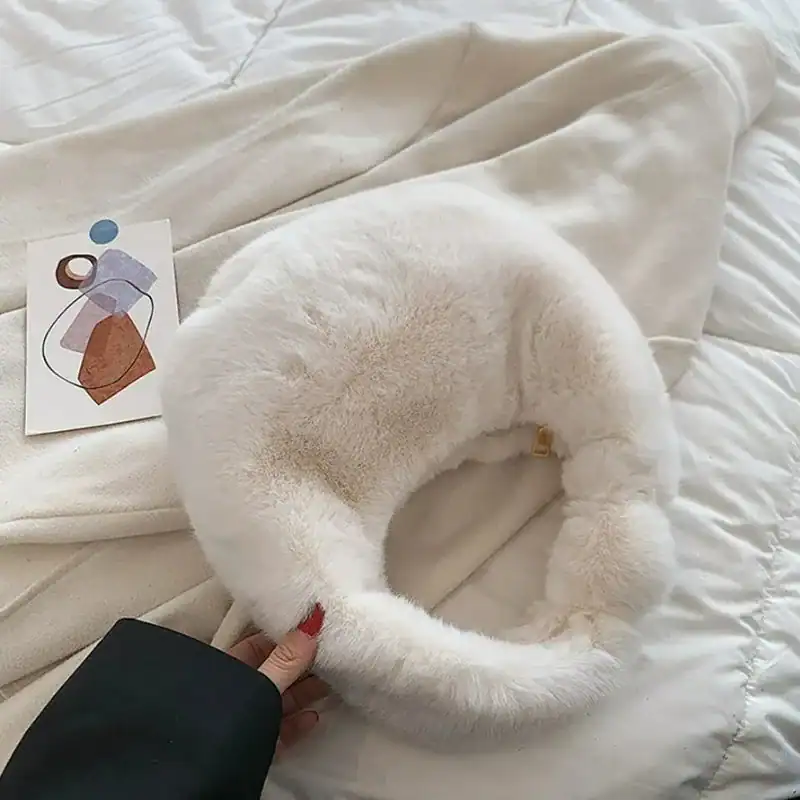 Grå fluffig hobo axelväska med mjuk pälsliknande yta och rund form.