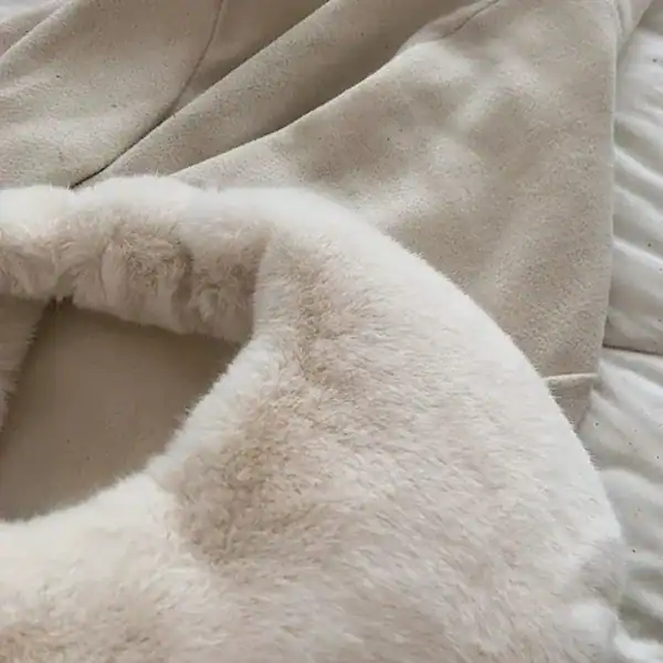 Grå fluffig hobo axelväska med mjuk pälskant och runt handtag.