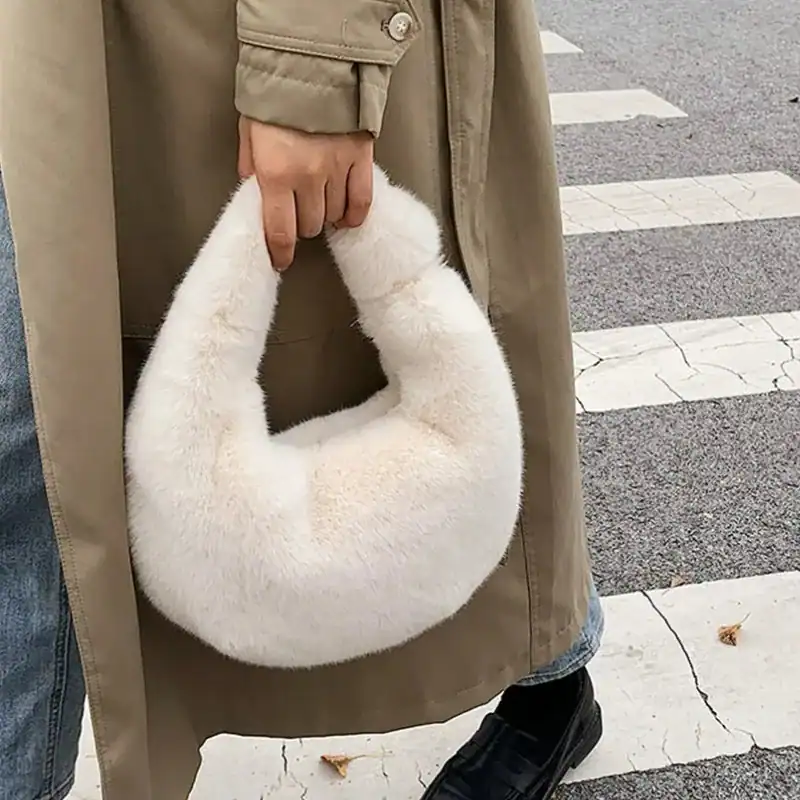 Grå fluffig hobo axelväska med mjuk pälsliknande yta och runt handtag.