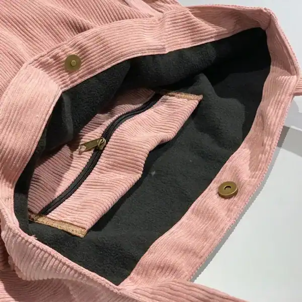 Grå Manchester shoppingväska i rosa corduroy med svart inre och metallknappar.