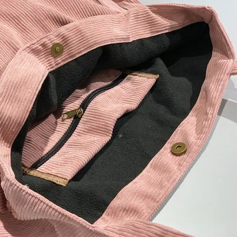 Grå Manchester shoppingväska i rosa corduroy med svart inre och metallknappar.