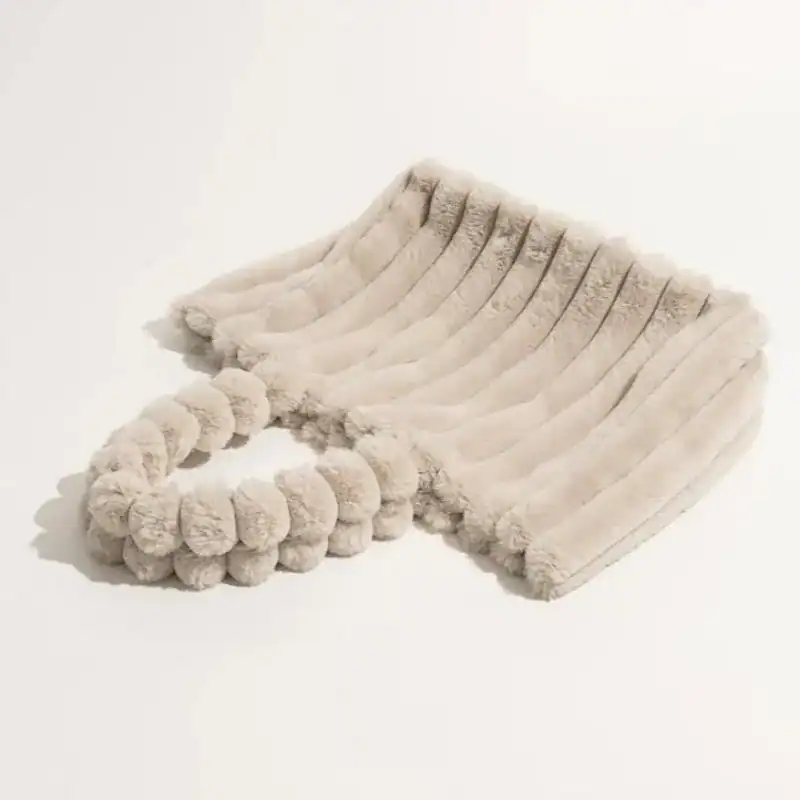 Grön fluffig shoppingväska med pärlformade pomponer på handtaget.