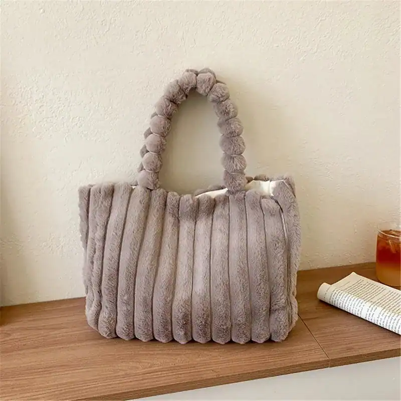 Grön fluffig shoppingväska med pärlformade handtag och rördesign.