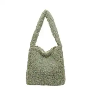 Grön teddyväska med fluffig textur och höga handtag.