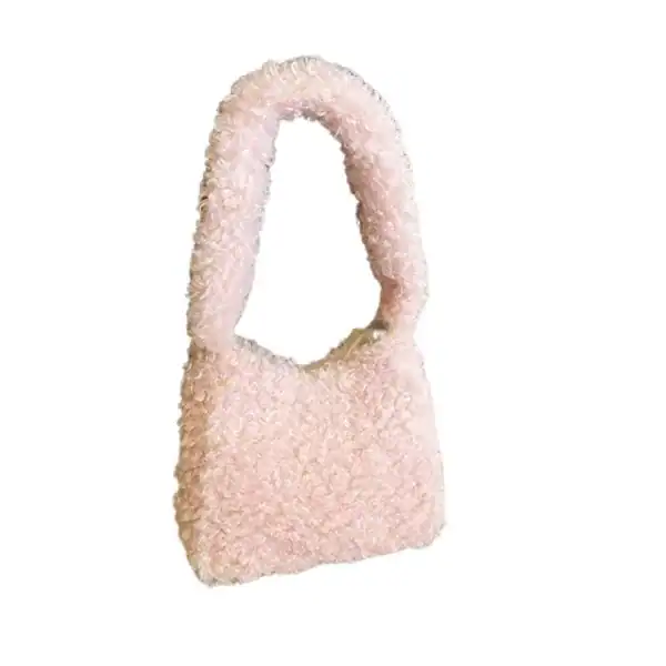 Grön teddyväska med mjuk pälsliknande yta och runt handtag.