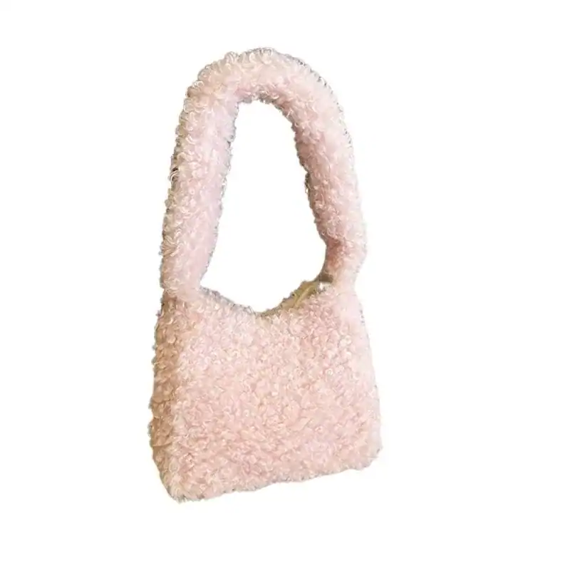 Grön teddyväska med mjuk pälsliknande yta och runt handtag.