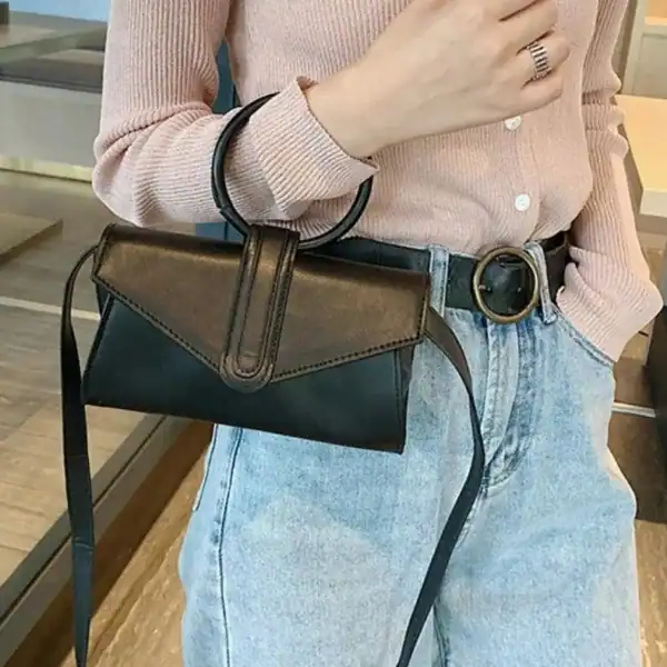 Gul axelväska med runt handtag, läderliknande material och axelrem.
