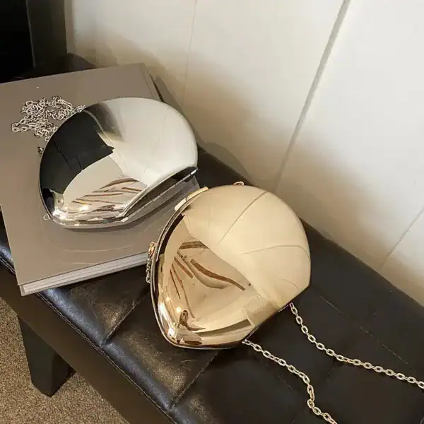 Guld clutch med kedjehandtag, spegelglans och elegant design.