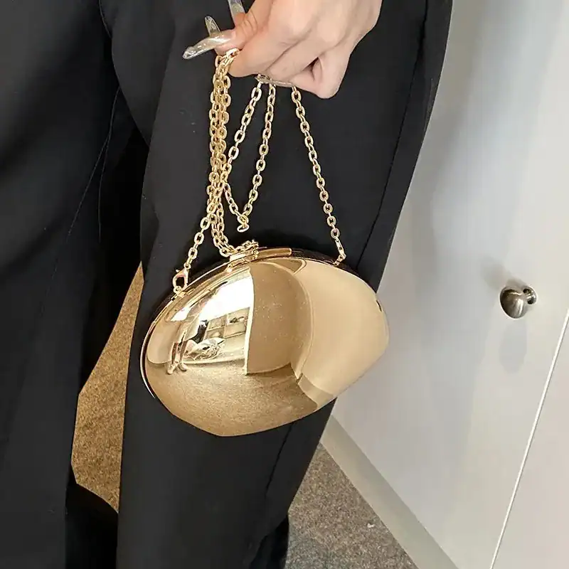 Guld clutch med kedja, elegant och trendig axelväska för kvällsarrangemang.