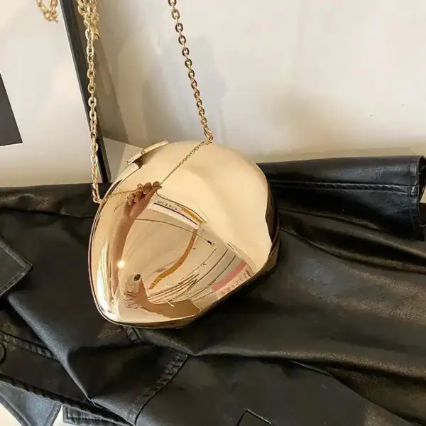 Guld clutch med kedjehängare och spegelblank yta.