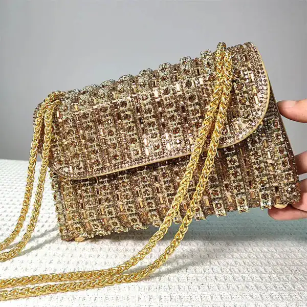 Guld kuvertväska med strass och kedjehandtag, perfekt för festliga tillfällen.
