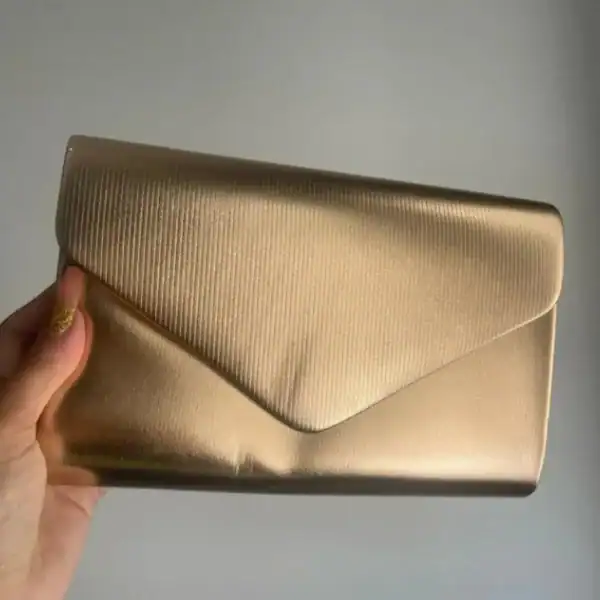 Guld satinclutch med strukturerad yta och envelope-design.
