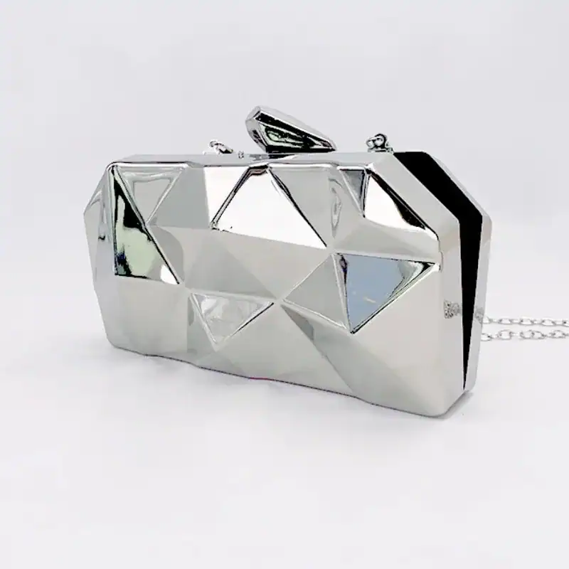 Guldig geometrisk clutch med silverfärgad yta och kedjehållare.
