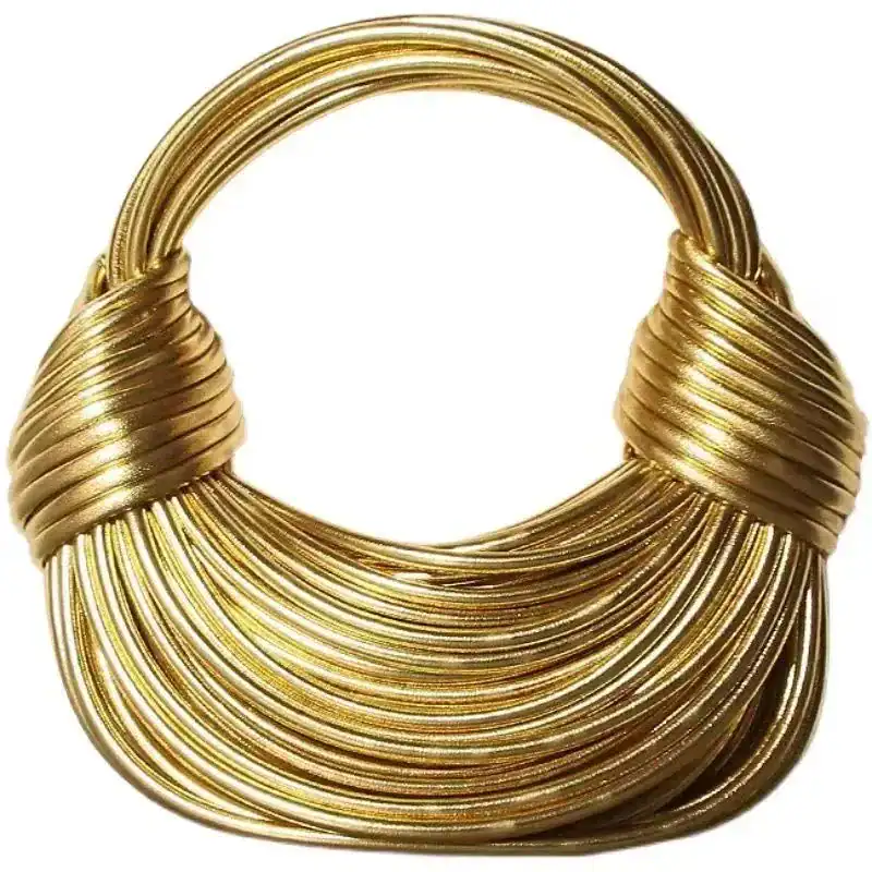 Guldig knuten väska med elegant, runt handtag och glittrande guldtonad yta.