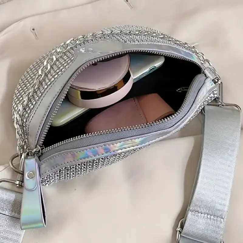 Guldig midjeväska med strass och holografiskt material, öppen ficka visar innehåll.