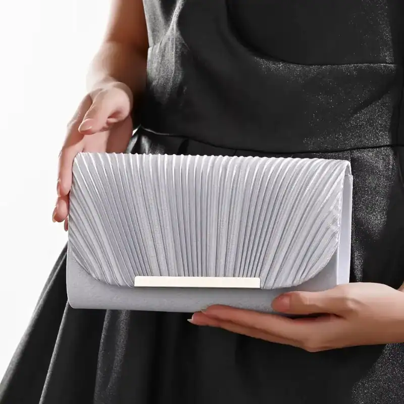 Guldig plisserad clutch i silver, elegant axelväska med rörlig plissé och metalliskt snör.