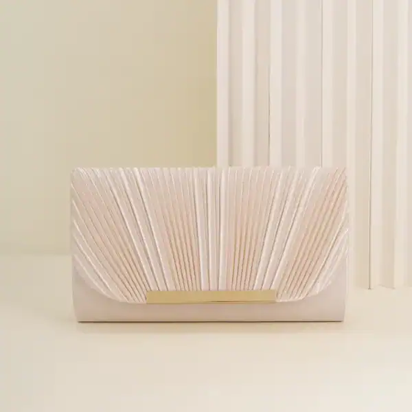 Guldig plisserad clutch i ljusrosa med gyllene snäckskalformad snabbklick.