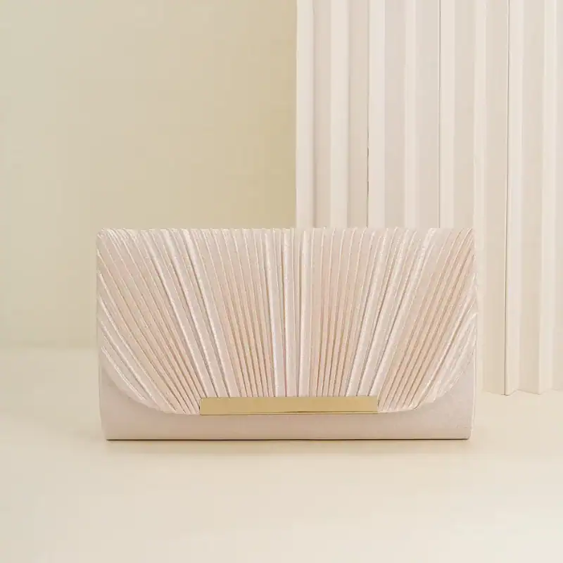 Guldig plisserad clutch i ljusrosa med gyllene snäckskalformad snabbklick.