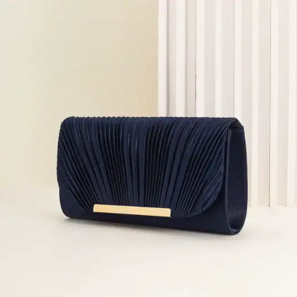 Guldig plisserad clutch i mörkblått med gyllene detaljer och eleganta rynkor.