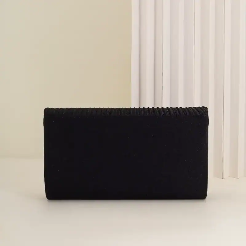 Guldig plisserad clutch i svart, elegant axelväska med glittrande detaljer.