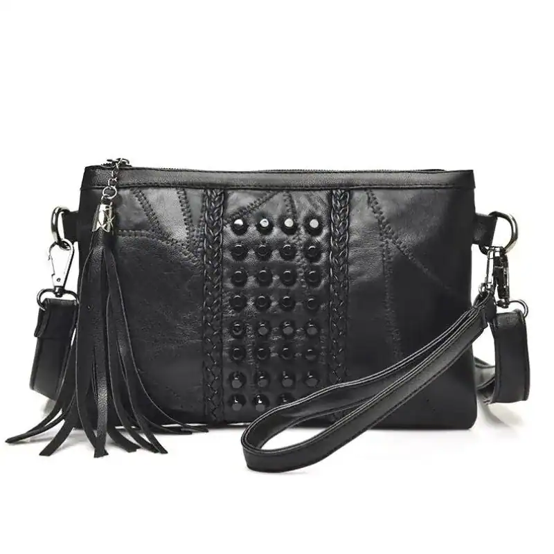 Svart handväska med nitar, studded detaljer och fransar.