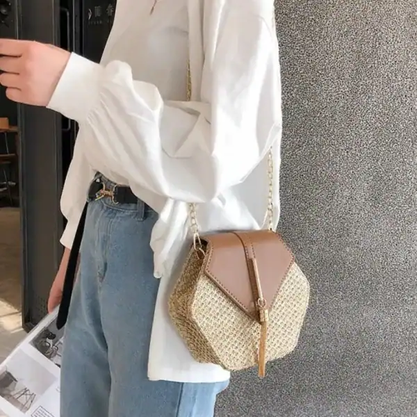 Hexagonal stråväska i beige med brun läderdetalj och kedjehandtag.