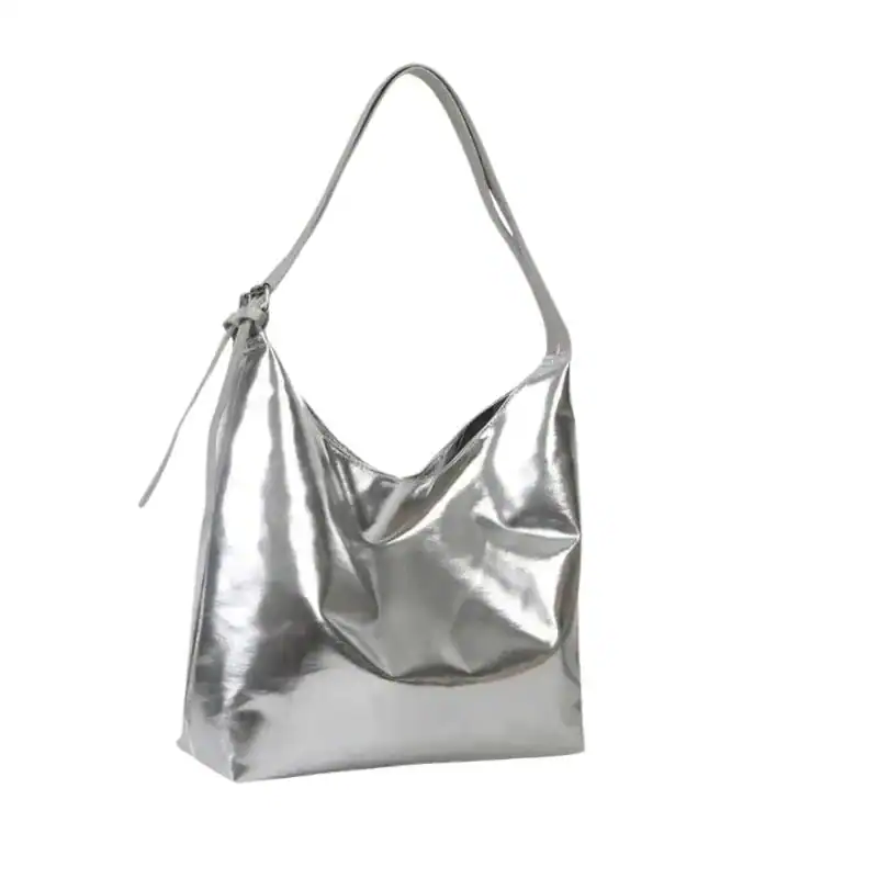 Silver hobo handväska med glansig yta och axelrem.