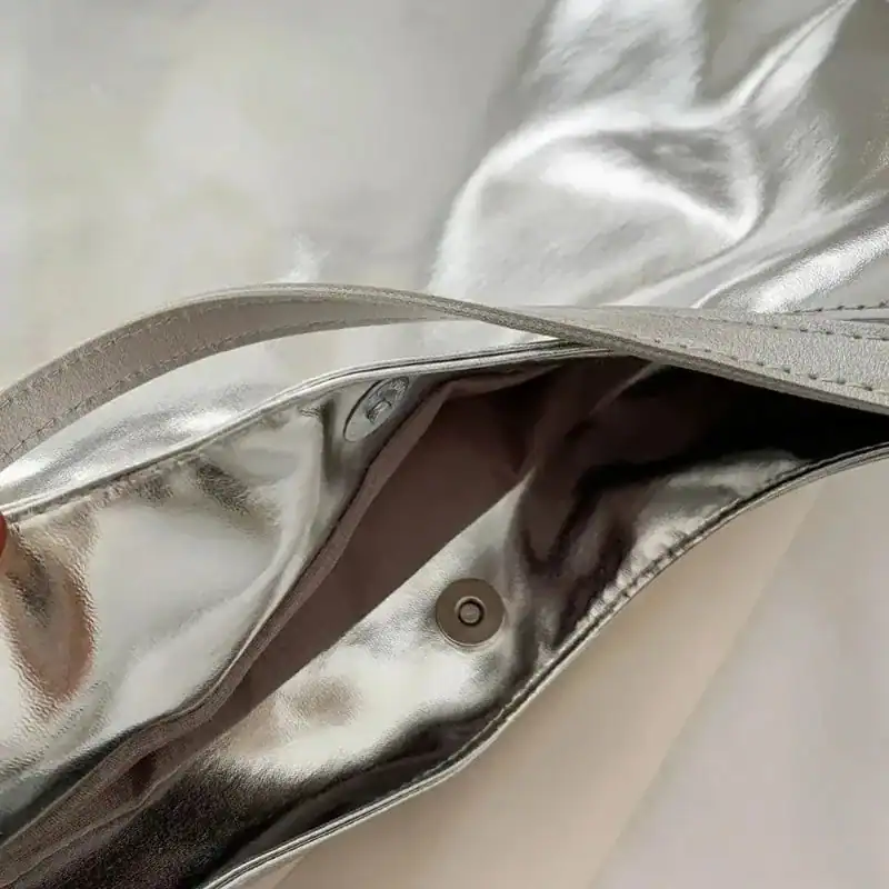 Silver hobo handväska med glansig yta och inre färg.