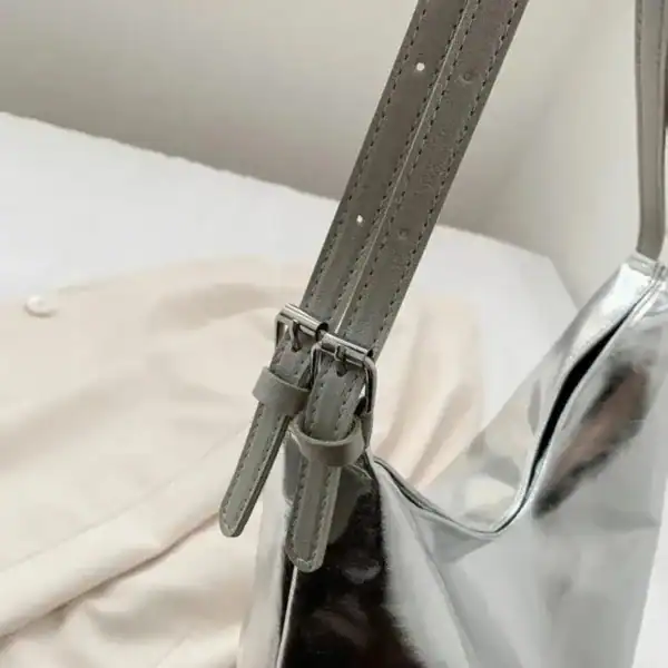 Silver hobo handväska med justerbar axelrem och metallficka.