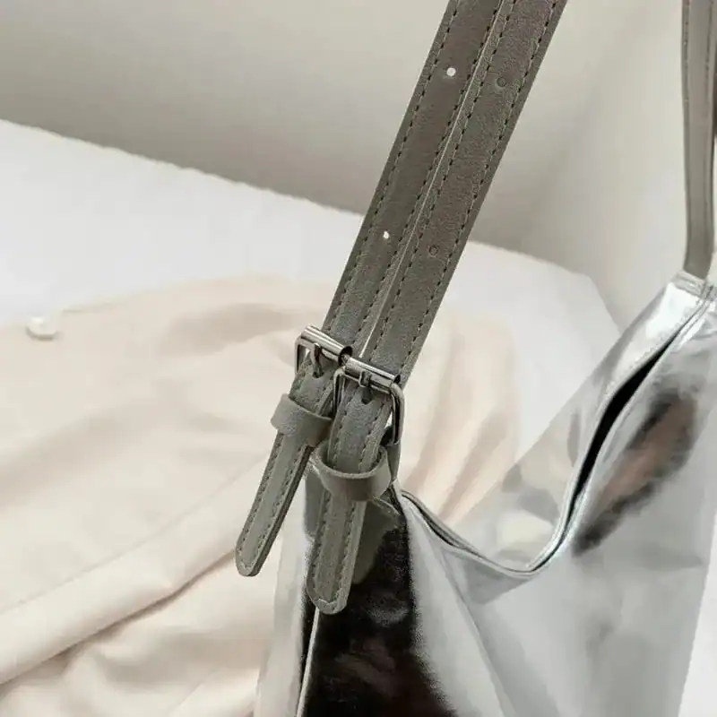 Silver hobo handväska med justerbar axelrem och metallficka.