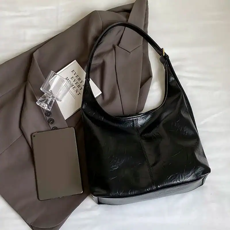Svart hobo väska i läder med hög handtag, stilren och trendig för vardag och mode.