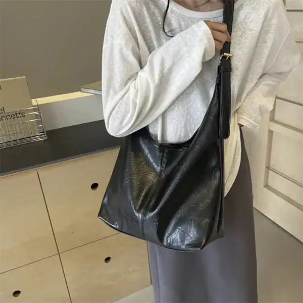 Svart hobo väska i läder med textur, bära på axeln, modeaccessoarer för kvinnor.