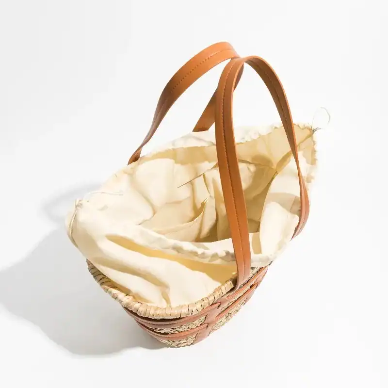 Liten korgväska med läderhandtag och beige inre, perfekt för daglig användning.