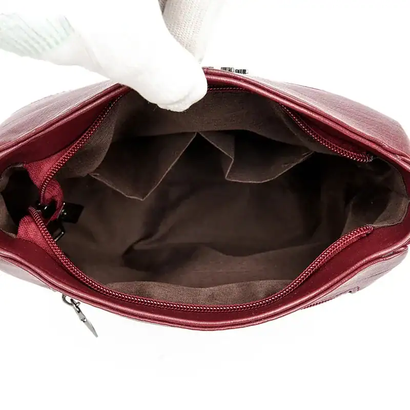 Krämvit crossbody väska, inre med fickor och dragkedja.
