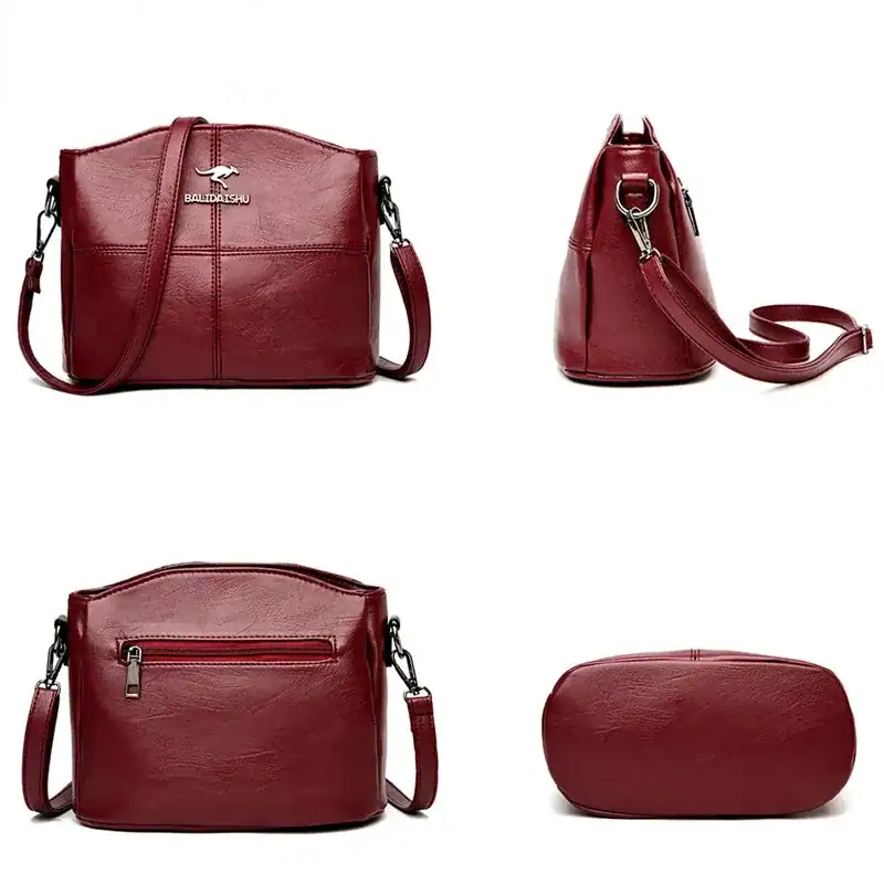 Krämvit crossbody väska med axelrem, läderliknande material och frontficka.