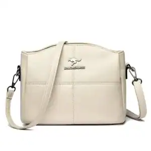 Krämvit crossbody väska med detalj och justerbar axelrem.