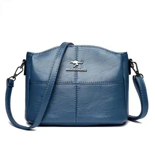 Krämvit crossbody väska i blått läder med axelrem och logo.