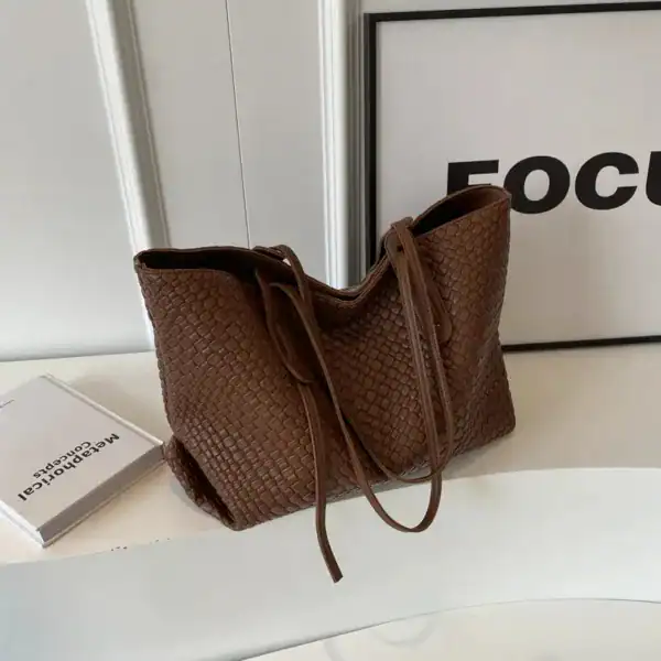 Krämvit flätad shoppingväska med lös handtag, trendig och praktisk för vardag.
