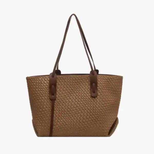 Krämvit flätad shoppingväska med bruna läderhandtag och praktisk design.