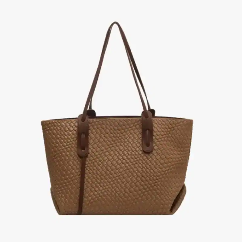 Krämvit flätad shoppingväska med bruna läderhandtag och praktisk design.
